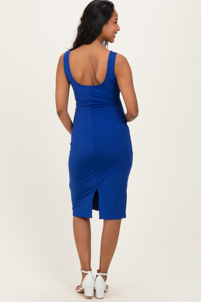 woman wearing a blue sleeveless maternity dress with a scoop back and a slit at the hem