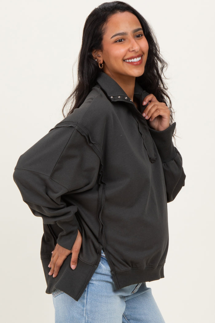 woman wearing a dark gray maternity pullover sweatshirt with a half zipper and relaxed fit, showing baby bump