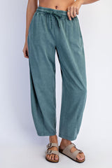 woman wearing teal wide-leg pants with an elastic waistband and side pockets paired with tan sandals