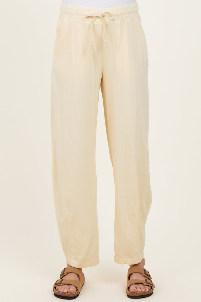 woman wearing cream maternity jogger pants with an elastic waistband and side pockets