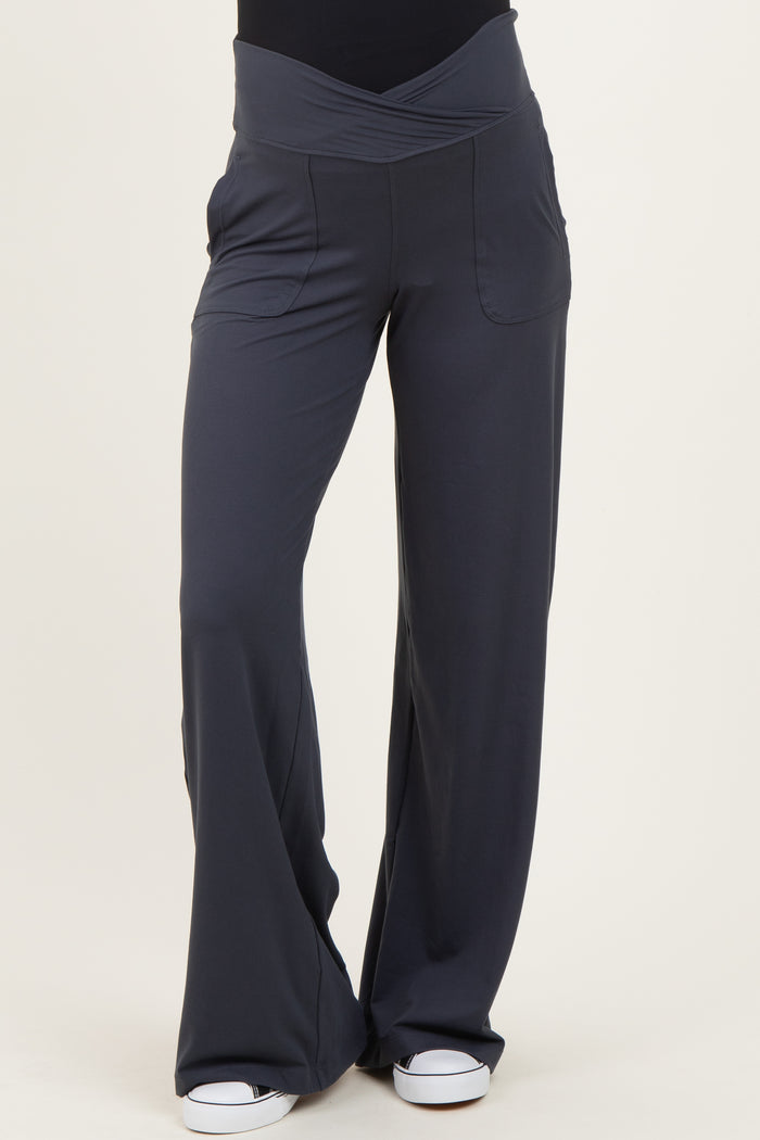 woman wearing dark gray maternity pants with a wide waistband and pockets