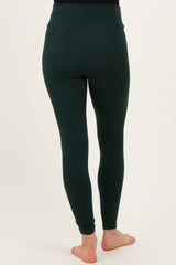 woman wearing dark green maternity leggings, showing the backside view