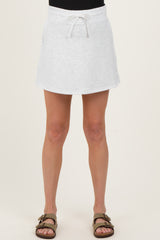 woman wearing a light gray maternity skirt with a drawstring waist and a relaxed fit