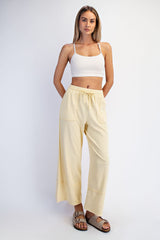 woman wearing a white crop top and yellow wide-leg pants with side pockets and drawstring waist