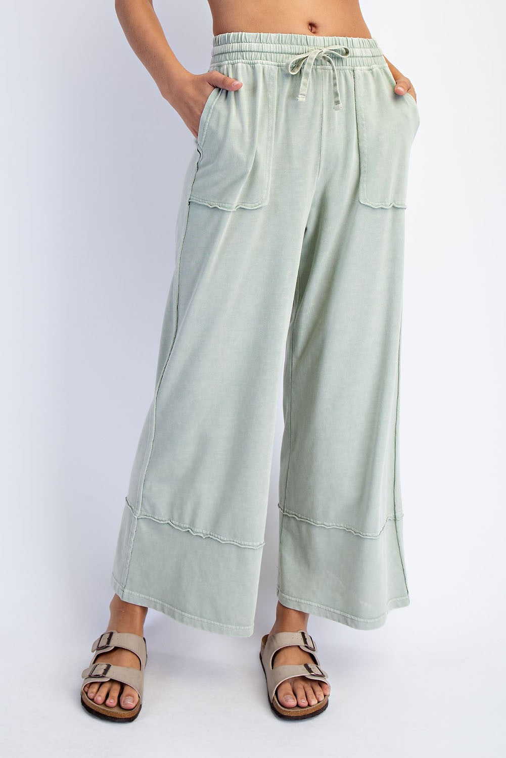 woman wearing light green wide-leg pants with pockets and drawstring waist