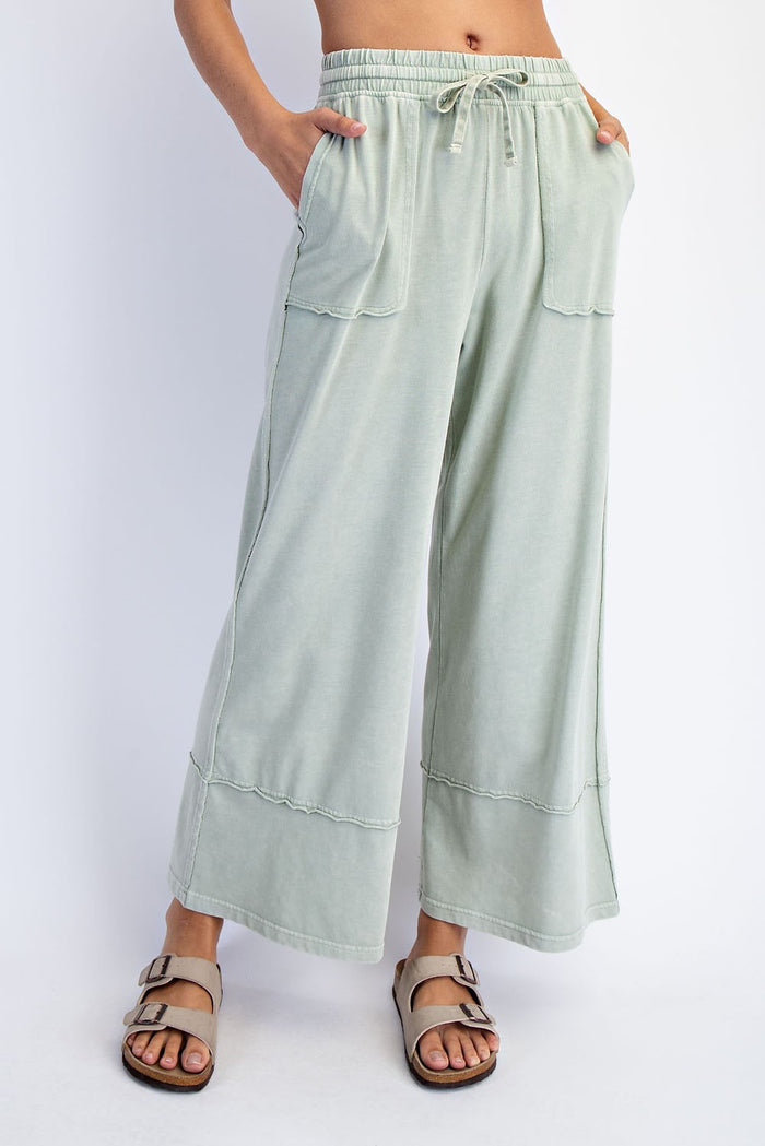 woman wearing light green wide-leg pants with pockets and drawstring waist