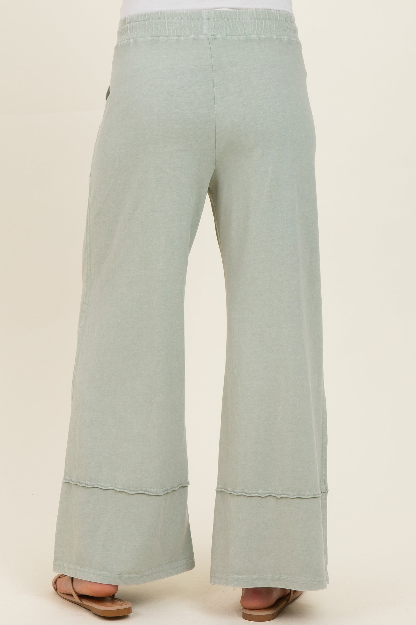 woman wearing light green wide-leg maternity pants with a comfortable waistband and side pockets