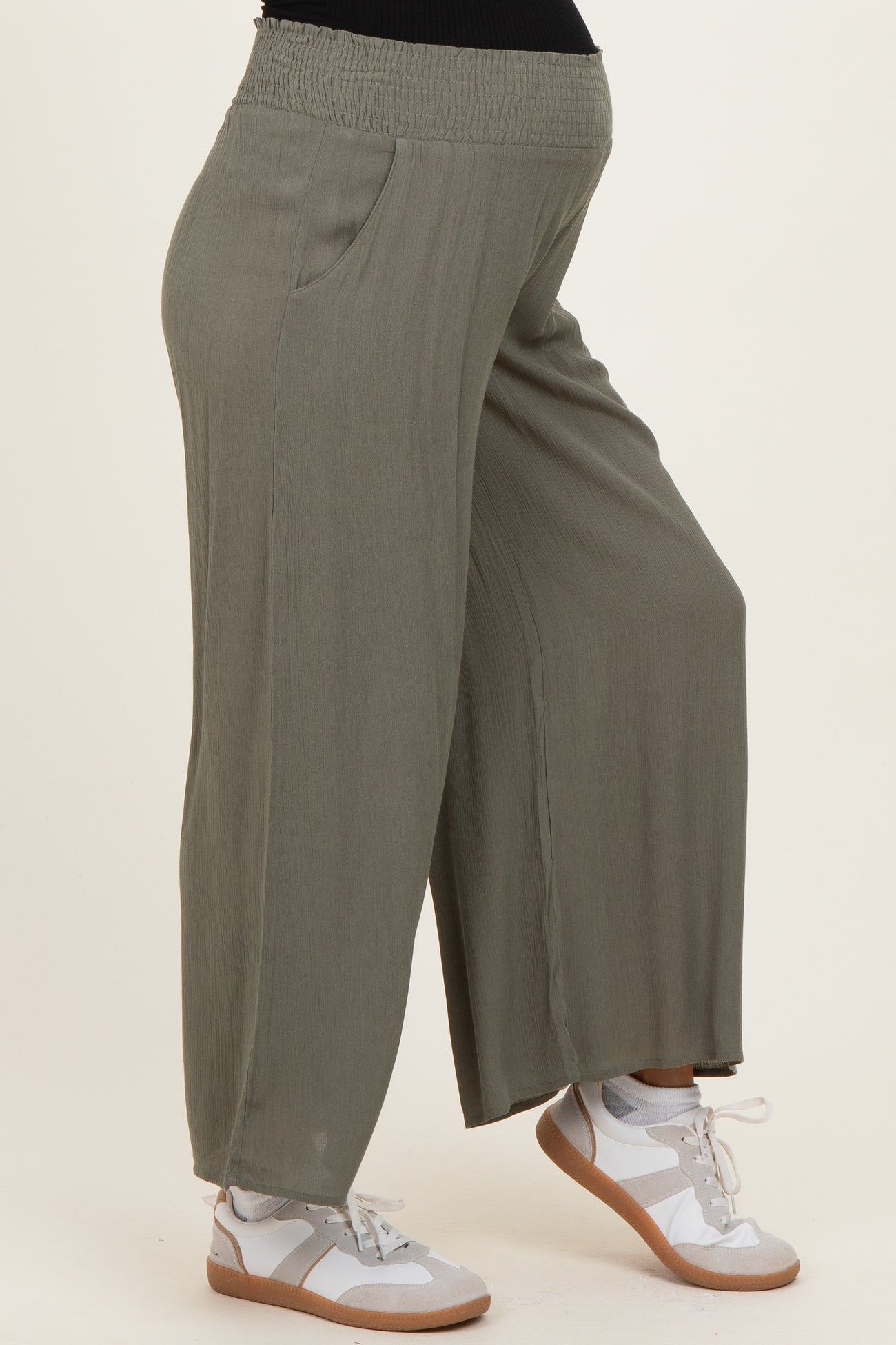 woman wearing olive green maternity wide leg pants with side pockets and a stretchy waistband