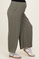 woman wearing olive green maternity wide leg pants with side pockets and a stretchy waistband