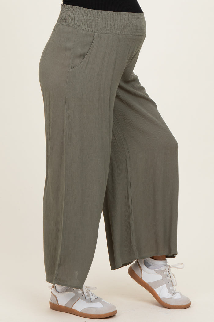woman wearing olive green maternity wide leg pants with side pockets and a stretchy waistband