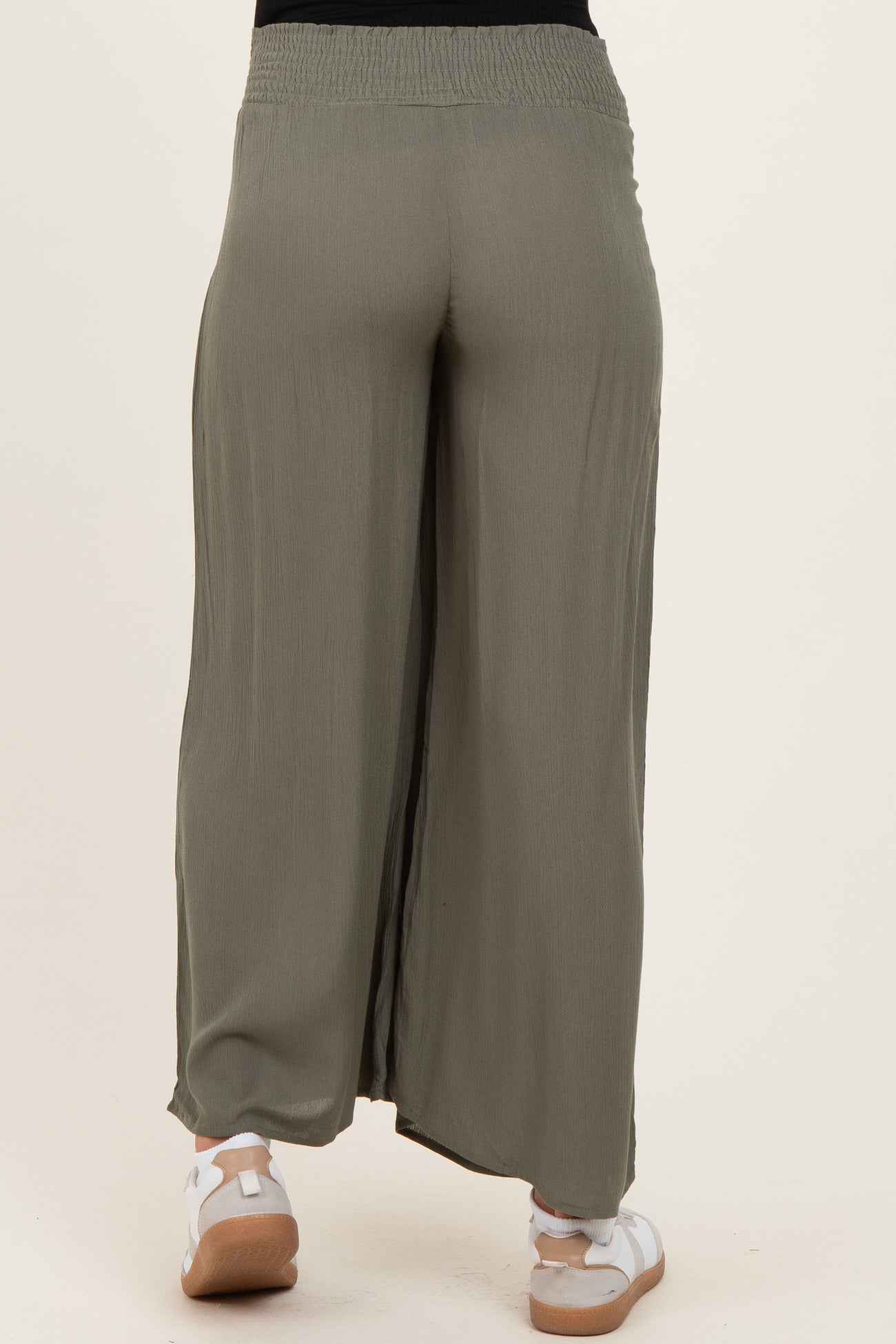 maternity wear olive green wide leg pants with a smocked waistband and side slits, model wearing white sneakers