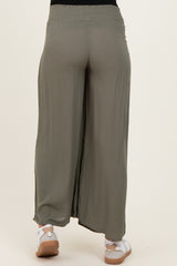 maternity wear olive green wide leg pants with a smocked waistband and side slits, model wearing white sneakers