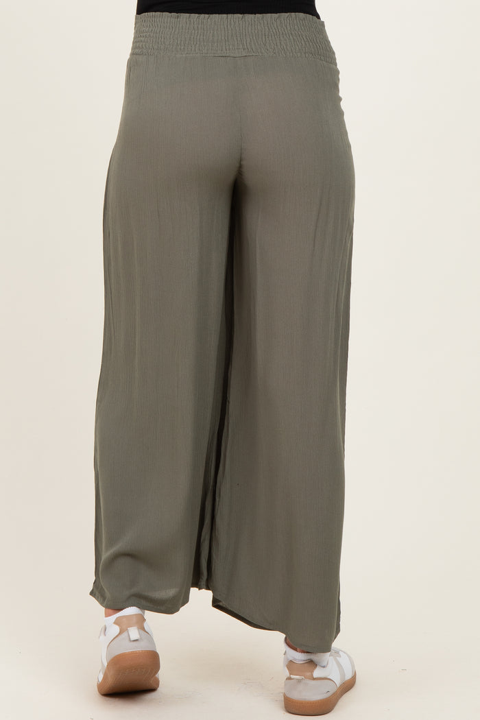 maternity wear olive green wide leg pants with a smocked waistband and side slits, model wearing white sneakers