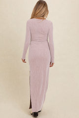 woman wearing a light pink ribbed long sleeve maternity dress with a side slit, showing her back