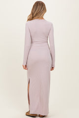 woman wearing a light pink long sleeve maternity dress with a fitted style and side slit