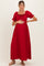 woman wearing a red ribbed maternity maxi dress with short puff sleeves and holding her baby bump