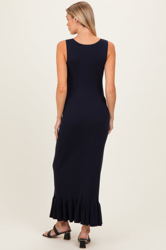 woman wearing a navy blue sleeveless maternity dress with a ruffled hemline and a fitted silhouette