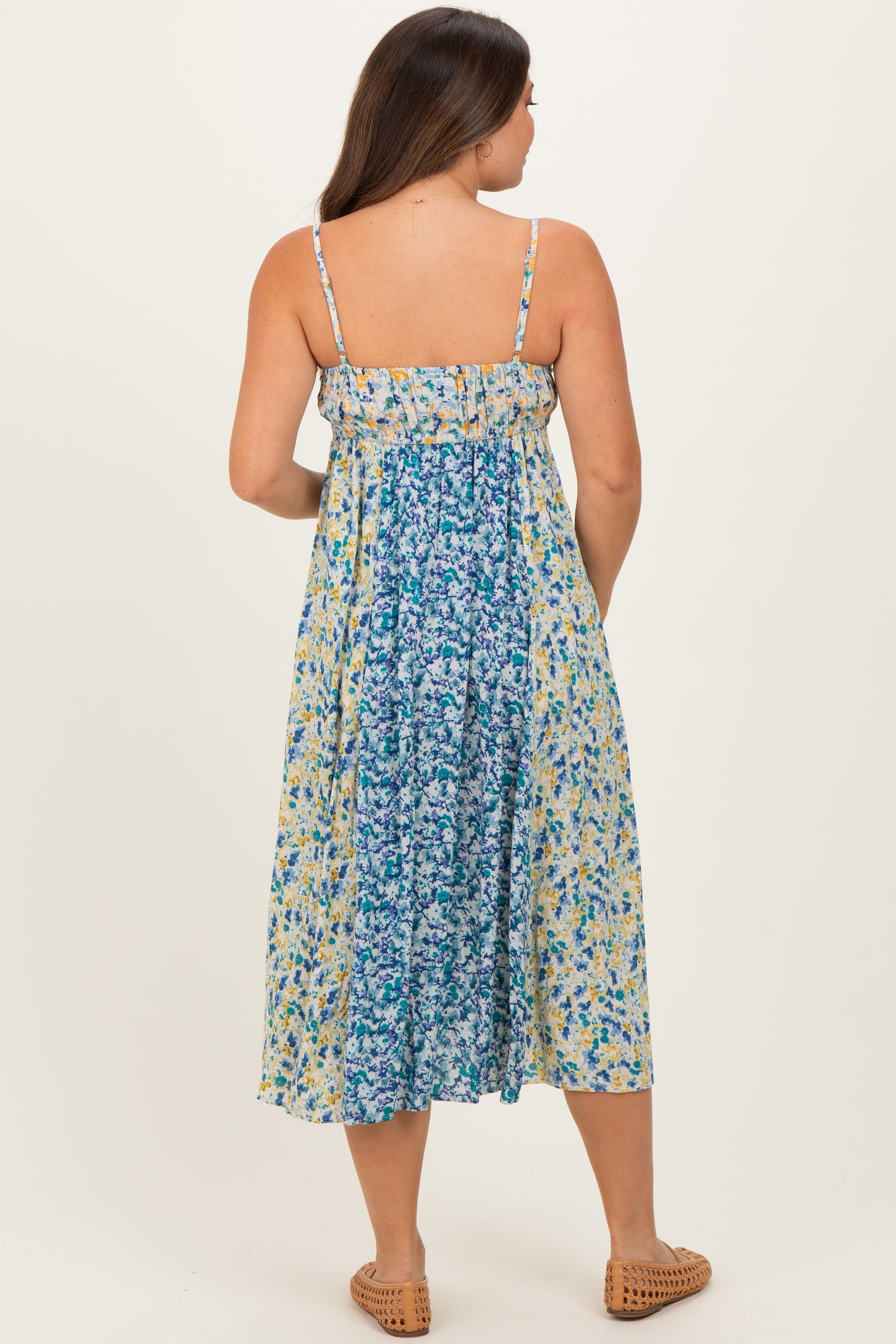 woman wearing a floral print maternity maxi dress with adjustable straps and a flowing silhouette