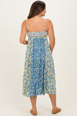 woman wearing a floral print maternity maxi dress with adjustable straps and a flowing silhouette