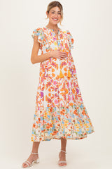 woman wearing a floral print maxi maternity dress with ruffle sleeves and a visible baby bump