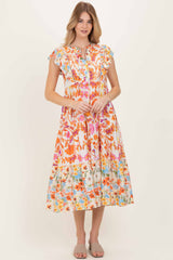 woman wearing a colorful floral midi dress with ruffled sleeves and a tiered skirt