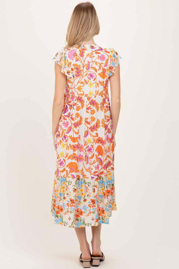 woman wearing a colorful floral print maxi dress with ruffled sleeves and a tiered hem, viewed from the back