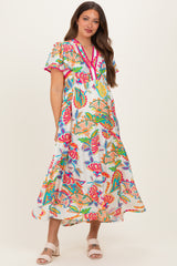 woman wearing a colorful floral print maternity dress with short sleeves and a tiered skirt