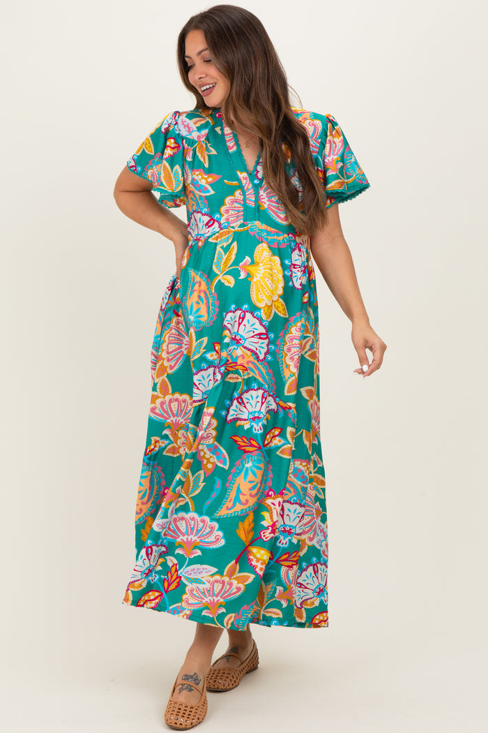 woman wearing a teal floral maternity maxi dress with short sleeves and a v-neckline