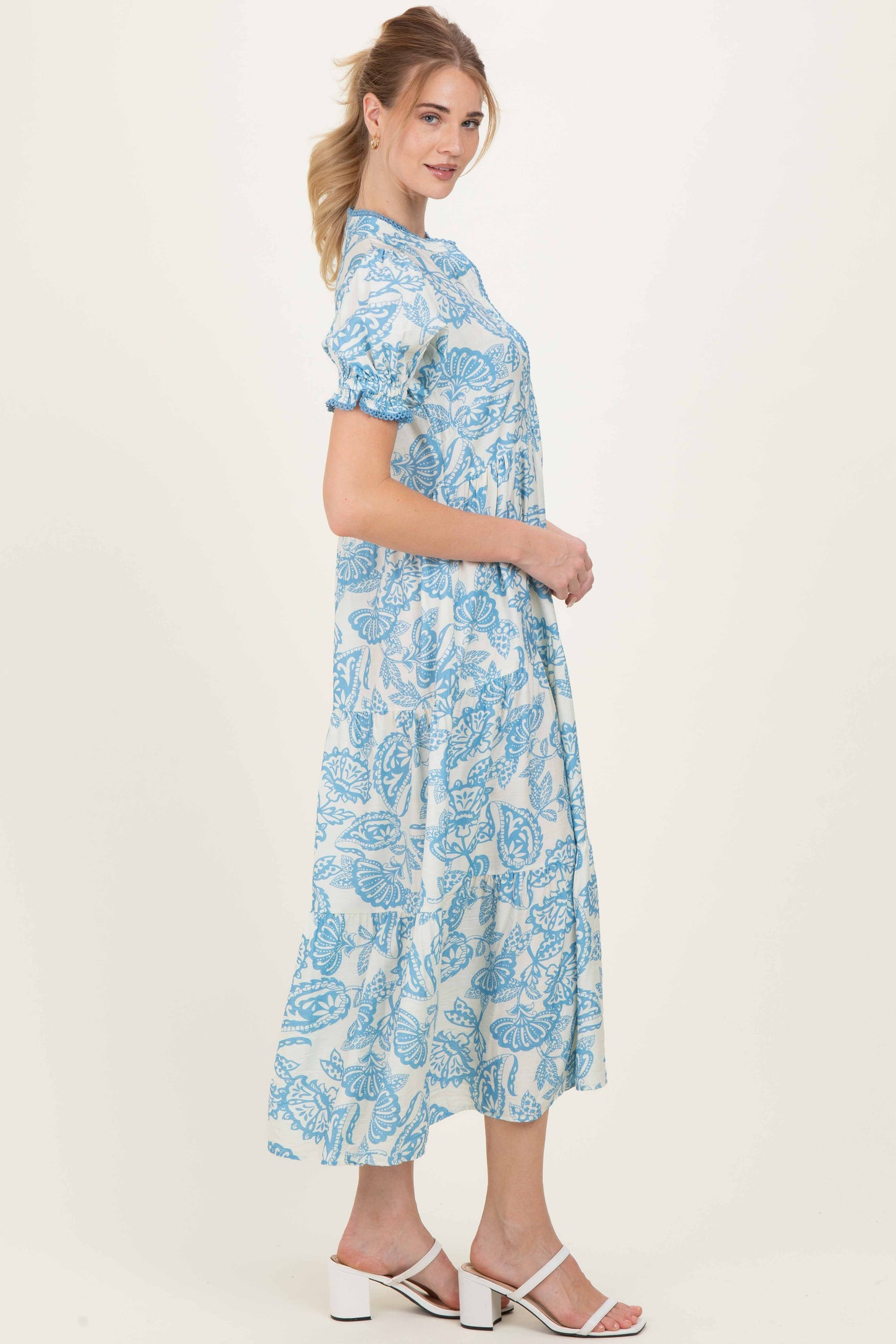 woman wearing a light blue floral maxi dress with short puff sleeves and a button-down front
