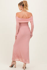 woman wearing a blush pink off-the-shoulder maternity dress with long sleeves and a fitted silhouette