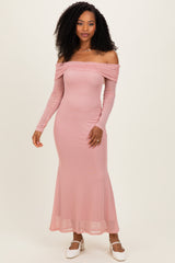 woman wearing a light pink off-the-shoulder long sleeve maxi dress with a fitted silhouette.