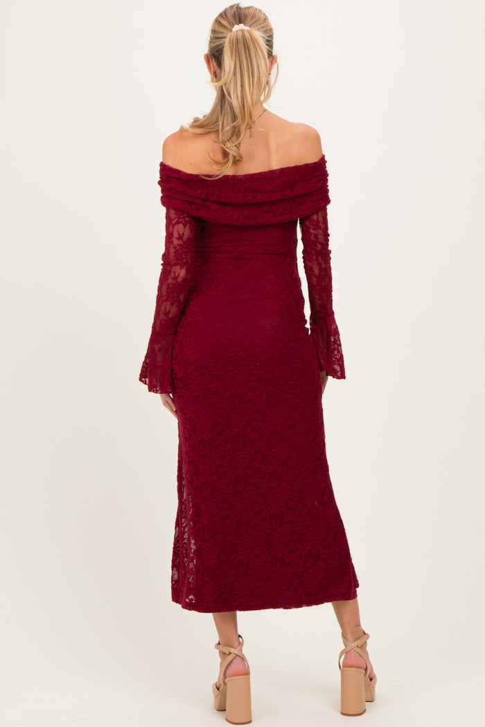 woman wearing a burgundy off-the-shoulder lace maternity dress with bell sleeves and a fitted silhouette