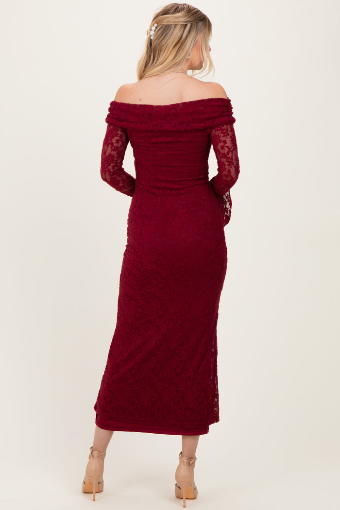woman wearing a burgundy off-the-shoulder lace gown with long sleeves and a fitted silhouette, observed from the back