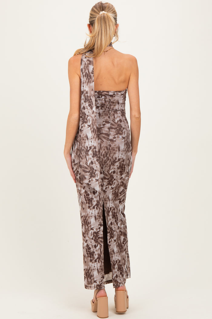 woman wearing a brown tie-dye one-shoulder maternity dress with a side slit and form-fitting silhouette