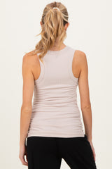 woman wearing a light beige maternity tank top with gathered details at the sides, viewed from the back