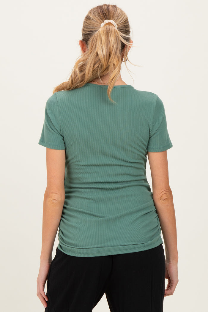 woman wearing a green maternity short sleeve top with ruching details on the sides