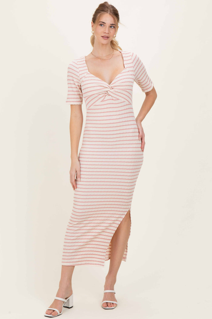woman wearing a striped midi dress with short sleeves and a side slit, styled with open-toe heels