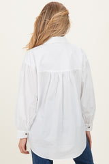 woman wearing a white maternity shirt with puff sleeves and gathered back detail