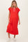 woman wearing a bright red maternity dress with a V-neck and short sleeves, standing and smiling