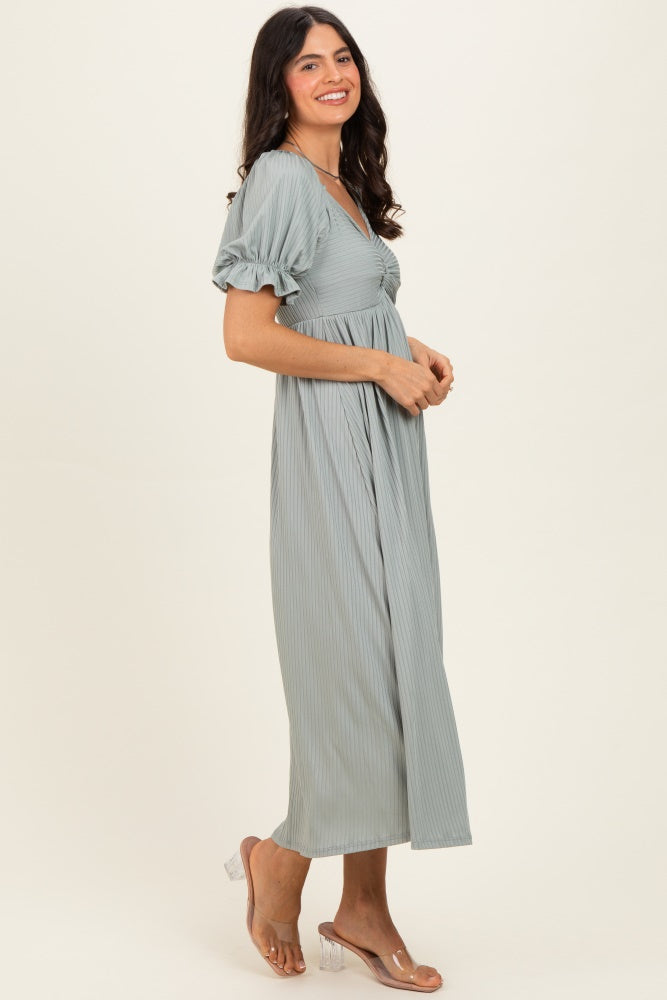 woman wearing a long sage green ribbed maxi dress with puff sleeves and a fitted bodice, smiling sideways