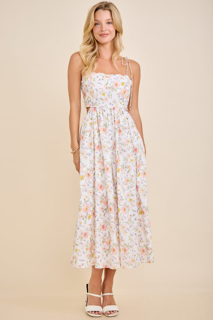 woman wearing a floral print midi dress with adjustable straps and a cinched waist