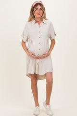 woman wearing a linen button-up maternity dress with short sleeves and a visible baby bump