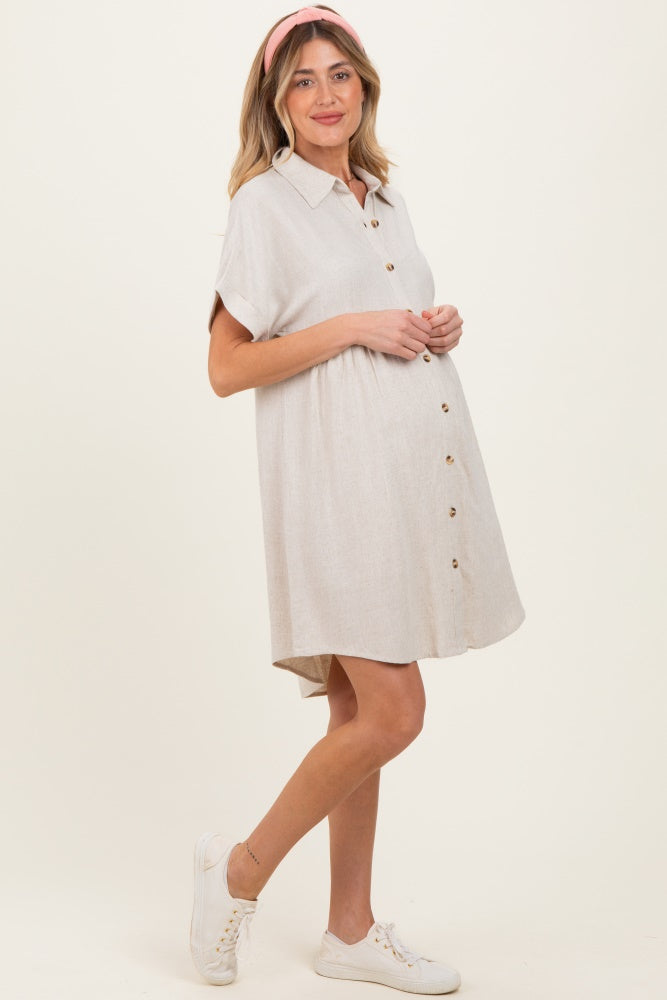 woman wearing a beige collared button-up maternity dress with a visible baby bump and a pink headband