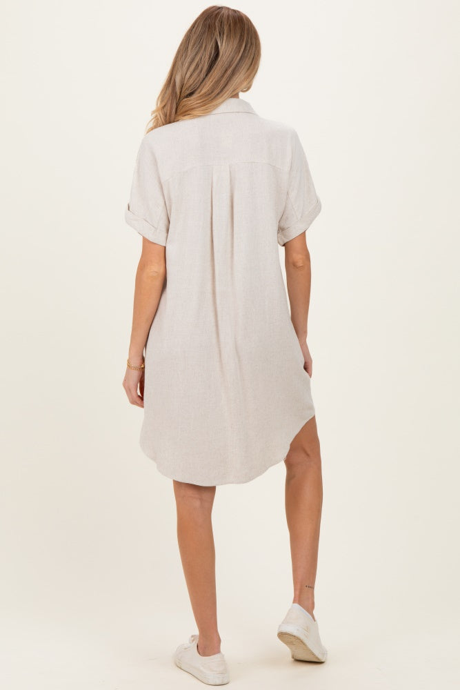 woman wearing a light beige maternity shirt dress with rolled sleeves and a curved hemline