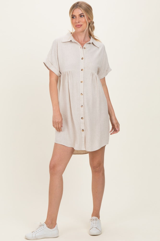 woman wearing a beige short sleeve button-up dress with a flared skirt and pockets, styled with white sneakers