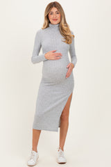 woman wearing a light grey ribbed maternity dress with a side slit, showing her baby bump, styled with white sneakers