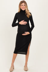 woman wearing a black ribbed maternity dress with a turtleneck and side slit, holding her baby bump
