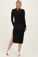 woman wearing a black ribbed long sleeve midi dress with a side slit and back view visible