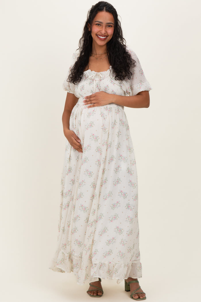 woman wearing a floral print maternity maxi dress and holding her baby bump