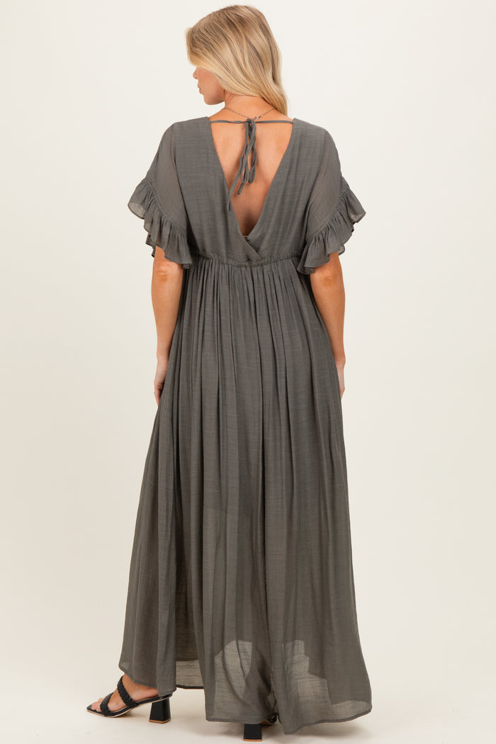 woman wearing a grey maternity maxi dress with ruffle sleeves and an open back, styled for comfort during pregnancy